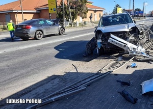 Policjanci podczas oględzin zabezpieczonego po pościgu samochodu. Widoczny także osobowy nissan, który został uszkodzony w wyniku zderzenia