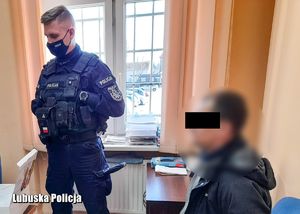 Policjant podczas czynności z zatrzymanym w biurze