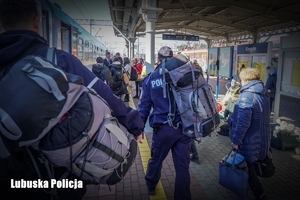 policjant niesie plecak pasażera