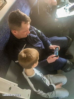 policjant gra z chłopcem na telefonie