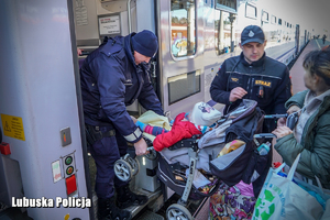 policjanci pomagają uchodźcom