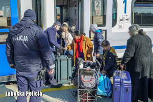 policjanci pomagają uchodźcom