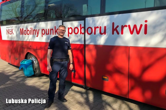 policjant stoi przy krwiobusie