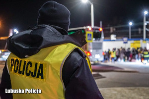 Policjant pilnuje bezpieczeństwa wsiadających do autobusu