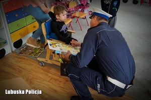 Policjant wręcza upominki dla chorego chłopca