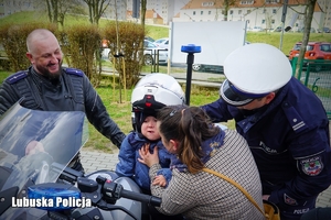 Chłopiec na motocyklu policyjnym w towarzystwie mamy i policjantów