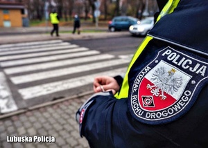 Policjant obserwuje ruch drogowy przy przejściu drogowym