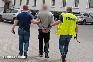 Policjanci prowadzą zatrzymanego