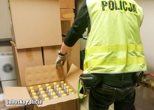 policjant przegląda zabezpieczony spirytus