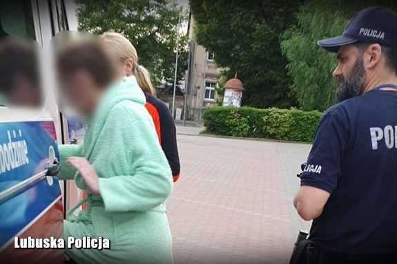 policjant i ratowniczka prowadzą seniorkę