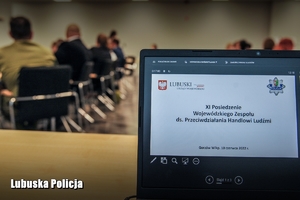 laptop i siedzące osoby w tle