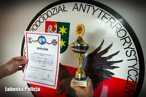 Logo Samodzielnego Pododdziału Kontrterrorystycznego Policji w Gorzowie Wielkopolskim ze zdobytym pucharem i dyplomem