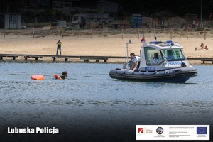 Policjanci na łodzi podpływają do przewróconego kajakarza