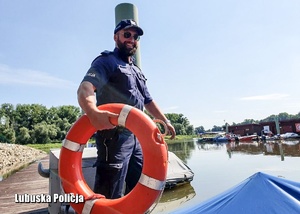 Policjant z kołem ratunkowym na pomoście.