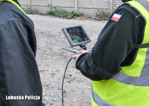 Policjant sprawdza teren georadarem