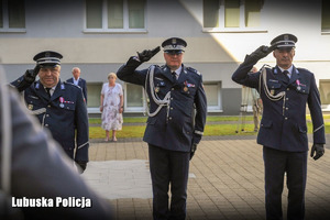 policjanci oddają honor w kierunku pomnika