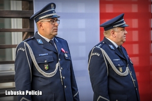 policjanci na tle biało-czerwonej flagi