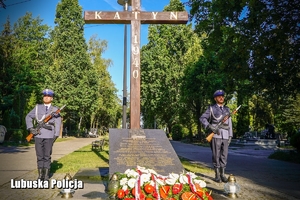 policjanci stoją przy Krzyżu Katyńskim