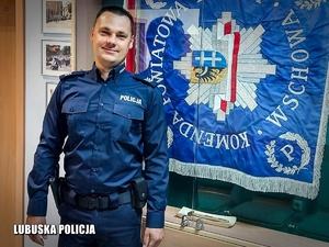 Policjant stojący przy sztandarze