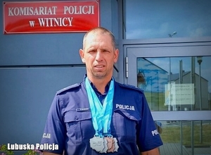 Policjant na tle komendy ze zdobytymi medalami