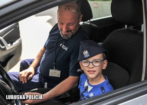 chłopczyk i policjant w policyjnym radiowozie