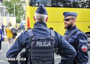 Policjanci oddziałów prewencji przy autokarze.