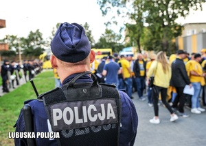 Policjant obserwuje ruch kibiców