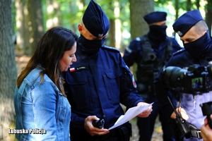 Policjanci i osoba zgłaszająca sprawdzają rysopis zaginionego