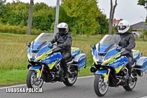 Policjanci jadący policyjnym motocyklem.