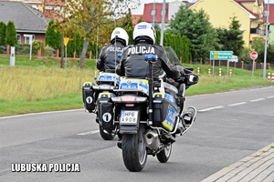 Policjanci jadący policyjnym motocyklem.