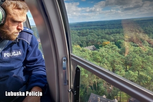 Policjant obserwuje rejon działania poszukiwań