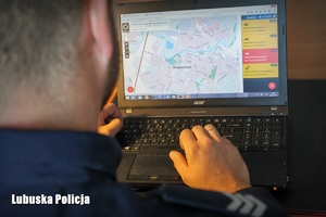 Policjant przed ekranem laptopa z otwartą Krajową Mapą Zagrożeń Bezpieczeństwa