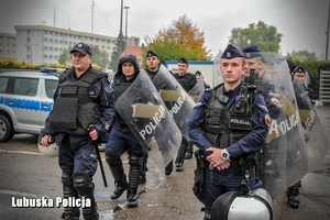 policjanci stoją z tarczami