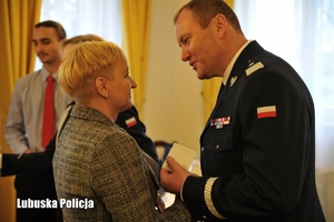 kobieta dzieli się opłatkiem z policjantem