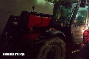 Ładowarka teleskopowa w pomieszczeniu magazynowym sprawdzana przez policjanta
