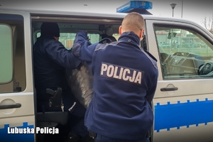 Policjanci pakują nakrętki do radiowozu