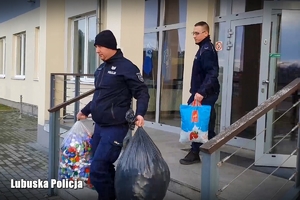 Policjanci noszą worki z nakrętkami