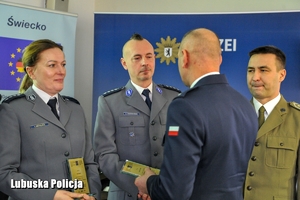 Policjant wręcza nagrody wyróżnionym