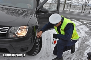 policjant kontroluje ogumienie pojazdu