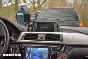 wnętrze radiowozu i policjanci kontrolujący pojazd na zewnątrz