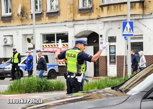 Policjant drogówki podczas kierowania ruchem na skrzyżowaniu.