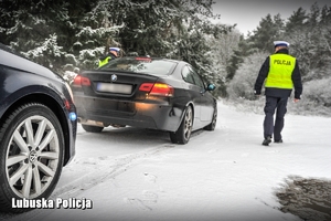 Policjant drogówki podczas kontroli pojazdu.