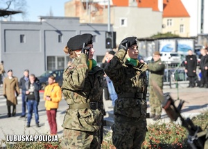 Żołnierze oddają hołd przed pomnikiem.