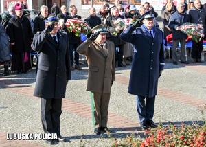 Komendanci służb mundurowych oddają hołd przed pomnikiem.