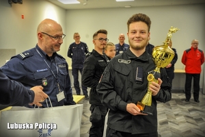 Chłopak odbiera nagrodę i gratulacje od naczelnika