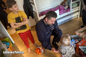 policjant wręcza dziecku słodycze