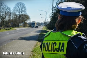 Policjantka obserwująca ruch pojazdów na drodze.
