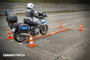 Policjant na motocyklu podczas pokonywania toru przeszkód.