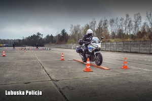 Policjant na motocyklu podczas pokonywania toru przeszkód.