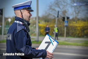 policjant trzyma kartkę z numerem